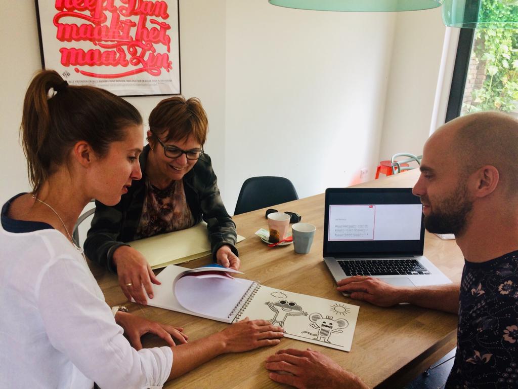Laura, de bedenkster (links), samen met Dorine (midden; vrijwilliger en productmanager tactiel lezen en leren bij Dedicon) en een illustrator (rechts) van Loulou&lou